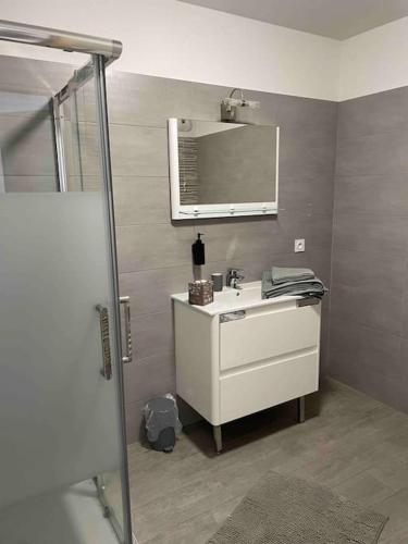 une salle de bain avec un lavabo blanc et un miroir dans l'établissement Très beau T2 idéalement situé., à Bastia