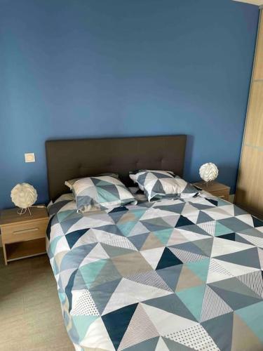 une chambre avec un grand lit avec un mur bleu dans l'établissement Très beau T2 idéalement situé., à Bastia