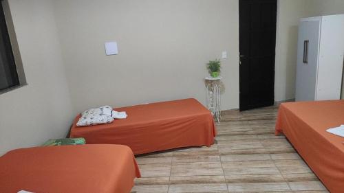 una habitación con dos mesas de naranja y una puerta negra en Pousada Apucarana en Apucarana