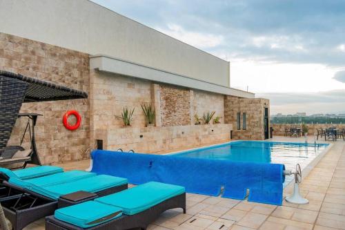 a swimming pool with a blue couch next to a building at Luxe Romance Retreat for Couples in Nairobi