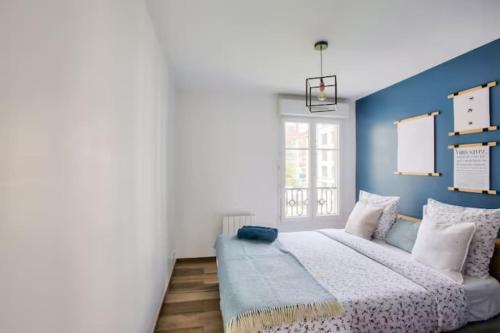 une chambre avec un lit et un mur bleu dans l'établissement Le Fantasia - Disney - Parking - Wifi, à Bussy-Saint-Georges