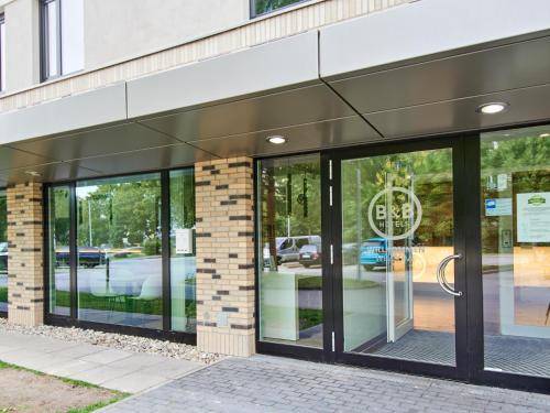 un devant de magasin avec portes en verre sur un bâtiment dans l'établissement B&B Hotel Frankfurt-West, à Francfort-sur-le-Main