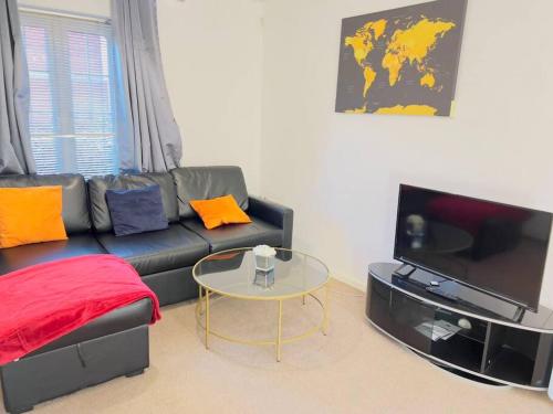 a living room with a black couch and a table at Starview Apartment-Vitoria in Lexden