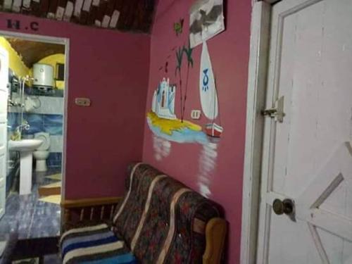 a bathroom with a bench in a pink wall at Azoz Nubian House in Aswan