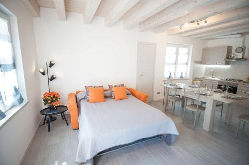 1 dormitorio con 1 cama con almohadas de color naranja y cocina en CASA GEMMA - Big Family House with Free Parking, en San Giovanni Lupatoto