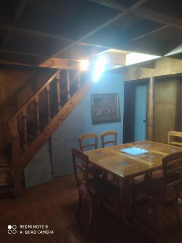 a dining room with a wooden table and chairs at Hostal norteña in Villa O'Higgins