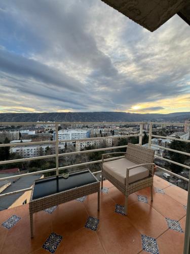 einen Balkon mit einem Stuhl, einem Tisch und Aussicht in der Unterkunft Tea's apartment in Tbilisi in Tbilisi City