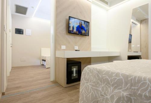 a bedroom with a bed and a tv on a wall at Hotel Harmony in Rimini