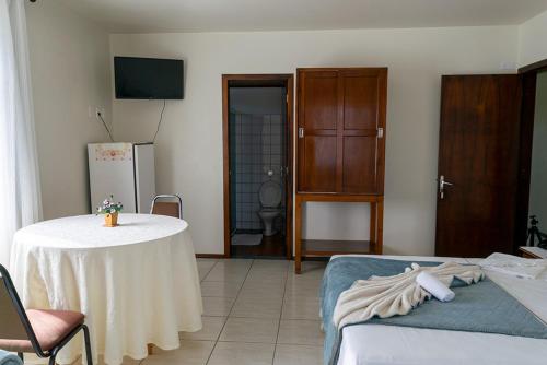 a living room with a table and a bed at HOTEL TAIÓ in Taió
