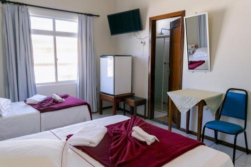 a hotel room with two beds and a mirror at HOTEL TAIÓ in Taió