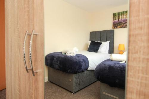 a bedroom with a bed with two ottomans at 2 Bedroom Flat in Colchester in Colchester