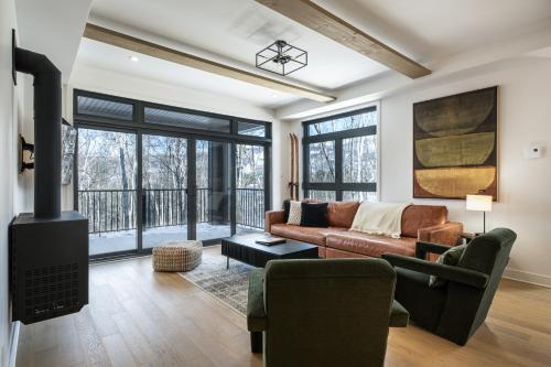 a living room with a couch and a fireplace at Tremblant Prestige - Verbier 4-105 in Mont-Tremblant