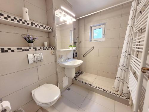 ein weißes Bad mit einem WC und einem Waschbecken in der Unterkunft Apartament Flora in Odorheiu Secuiesc