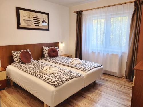 Bett in einem Zimmer mit einem großen Fenster in der Unterkunft Apartament Flora in Odorheiu Secuiesc
