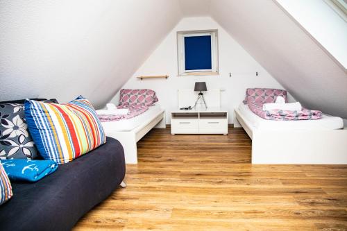a attic room with two beds and a couch at Ferienwohnungen Saida Wohnung 2 in Norden