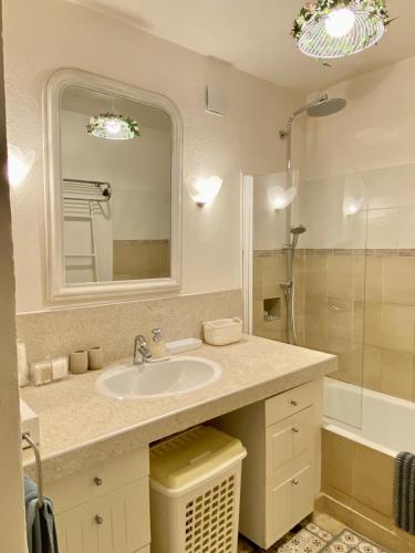 une salle de bain avec un lavabo, un miroir et une baignoire dans l'établissement Mas de Veroncle, piscine et quiétude à Gordes, à Gordes