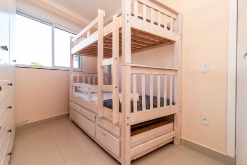 Apto com 3 quartos climatizados nos Ingleses HK2120 في فلوريانوبوليس: سرير بطابقين سلم في غرفة مع نافذة