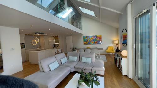 een woonkamer met een witte bank en een keuken bij Duplex 160m2 Paris JO 2024 in Vincennes