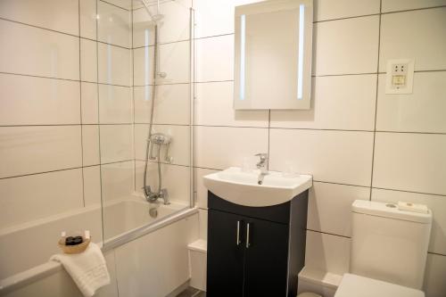 a bathroom with a sink and a shower and a toilet at Ashburnham Hotel in Pembrey