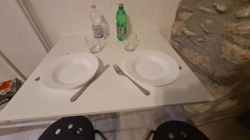 two white plates on a table with bottles and glasses at Il Campanile in Santa Maria del Molise