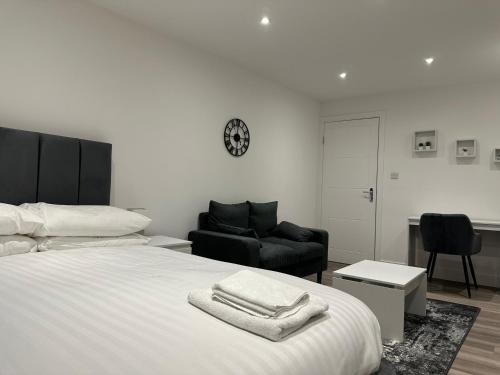 ein Schlafzimmer mit einem Bett, einem Stuhl und einem Tisch in der Unterkunft Modern Apartment in Luton town Centre in Luton