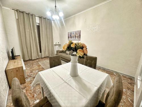 a dining room with a table with a vase of flowers on it at Maison Grimaldi Roma in Rome