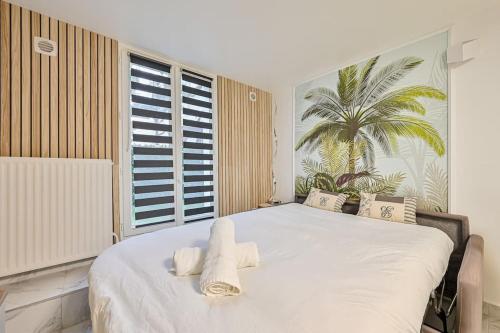 1 dormitorio con 1 cama blanca grande y toallas. en Le Sunny - Proche Paris - Terrasse, en Livry-Gargan