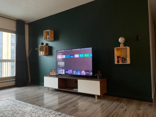 a living room with a large flat screen tv at Cosy Private Room in Downtown with Free Parking - Self entrance in Calgary