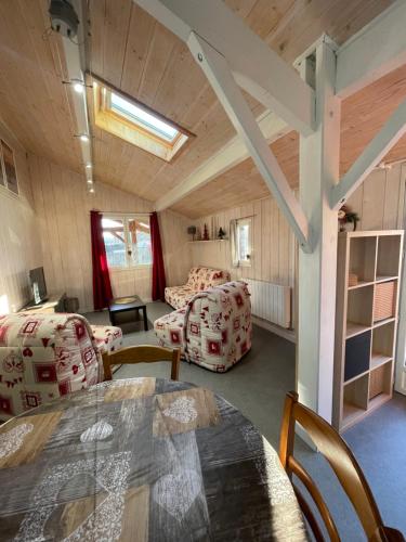 une chambre avec une table et des chaises ainsi qu'un salon dans l'établissement Les Cachettes du Hérisson - Le Hérissonneau, à Le Frasnois