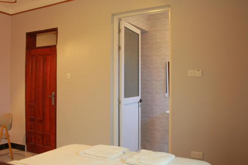 - une chambre avec une porte menant à une douche dans l'établissement S A Apartments, à Kampala