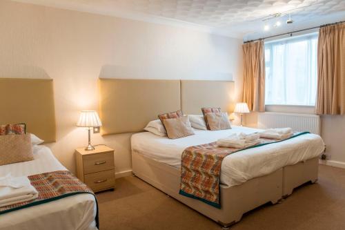 a hotel room with two beds and a window at Ashburnham Hotel in Pembrey