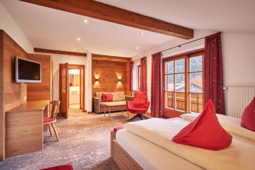 um quarto de hotel com duas camas e uma televisão em Landhotel Berghof em Bad Hindelang