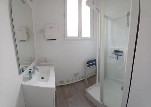 une salle de bain blanche avec une douche et un lavabo dans l'établissement Le Rayon Vert vue mer, à Fécamp