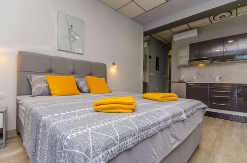 um quarto com uma cama grande com almofadas amarelas em Apartments Stay em Kaštela
