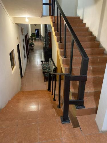 eine Treppe mit einem schwarzen Geländer in einem Gebäude in der Unterkunft Hotel Villa del Mar in Tonalá