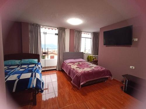 - une chambre avec un lit et une télévision à écran plat dans l'établissement Habitación doble con balcón. bonita vista, à Cajamarca