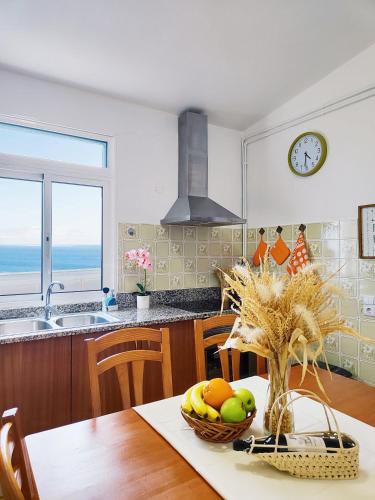 a kitchen with a table with a bowl of fruit at GATEONE AL Airport View House in Machico