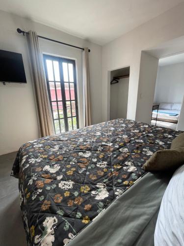 a bedroom with a bed with a blanket on it at Quinta La Perla in Guadalajara