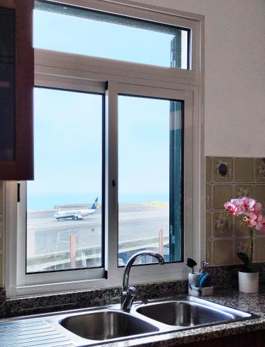 a kitchen window with a view of an airport at GATEONE AL Airport View House in Machico