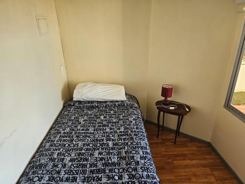 a small bedroom with a bed and a table at Cristian Andrades in Santiago