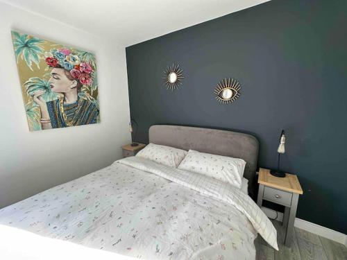 a bedroom with a bed and a painting on the wall at Gorgeous modern furnished cabin in Steyning in Steyning