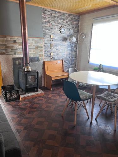 a living room with a table and a wood stove at Casa capdeville in Puerto Williams