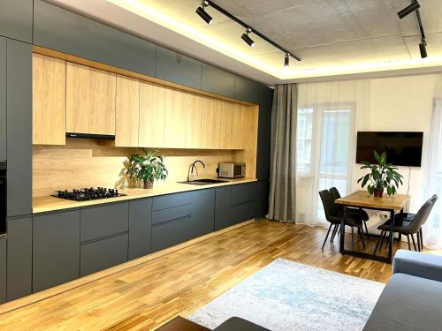 uma cozinha com armários de madeira e uma mesa com cadeiras em Comfortable apartment in a complex Great Britain em Lviv