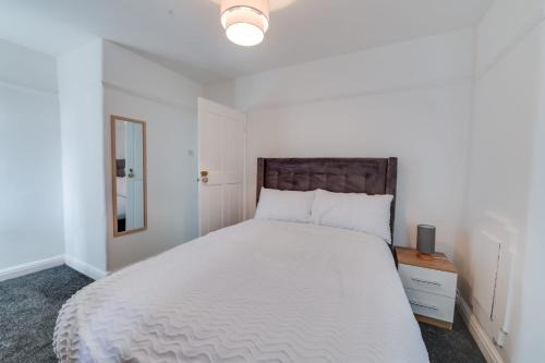 a bedroom with a large white bed with a wooden headboard at K50 Luxury Apartments in Middleton