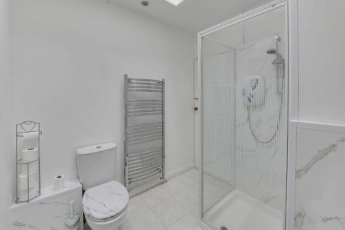 a white bathroom with a shower and a toilet at K50 Luxury Apartments in Middleton