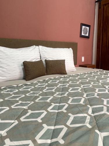 a bedroom with a large bed with white pillows at Quinta La Perla in Guadalajara
