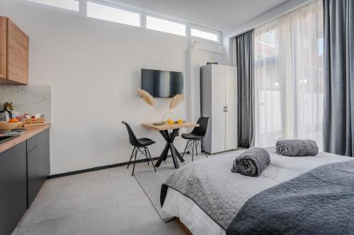 a bedroom with a bed and a table with chairs at Urban city apartment in Visoko
