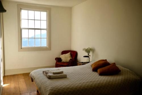 een slaapkamer met een bed, een raam en een stoel bij Casa Astória - City Centre Historical Building with Amazing River View in Porto