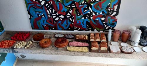 a bunch of different types of donuts on a shelf at Pousada restaurante recanto do Marimar in Paraty