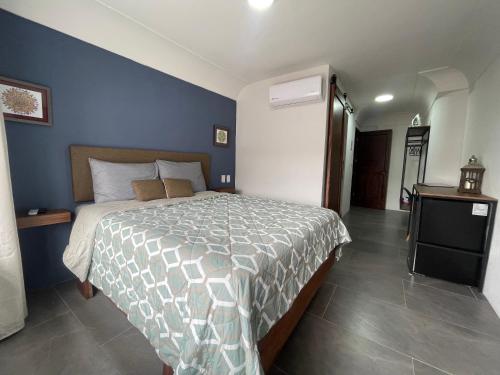 a bedroom with a bed and a blue wall at Quinta La Perla in Guadalajara